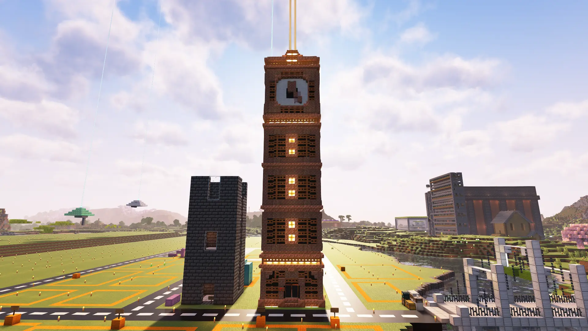 A tall orange copper clocktower sits in the middle of an unfinished city. Along the building's sides are yellow lights and an orange beacon comes out from the top of the structure.